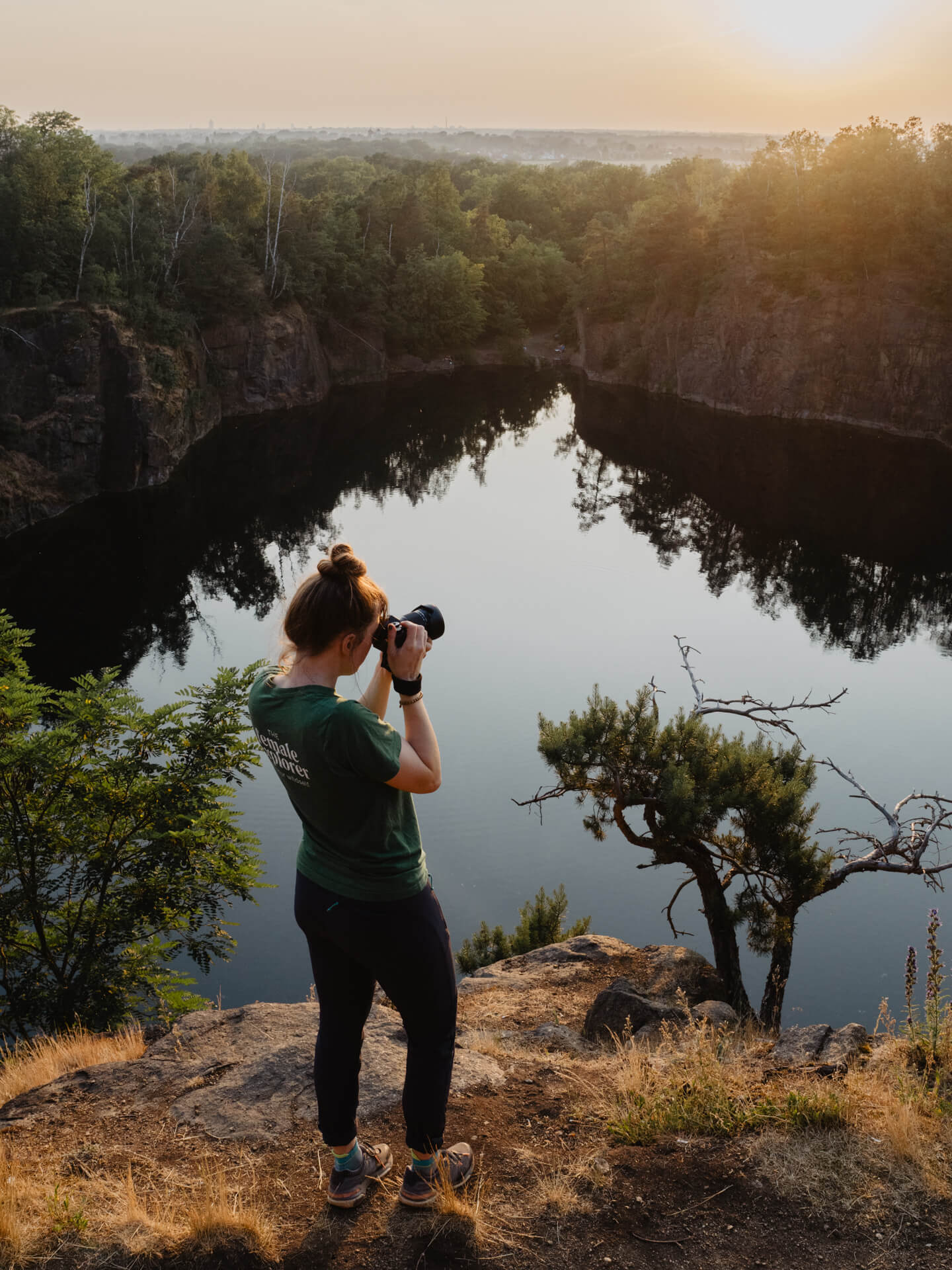 outdoor-fotografie: eine Frau steht vor einem See und hält eine Kamera vor dem Geschicht