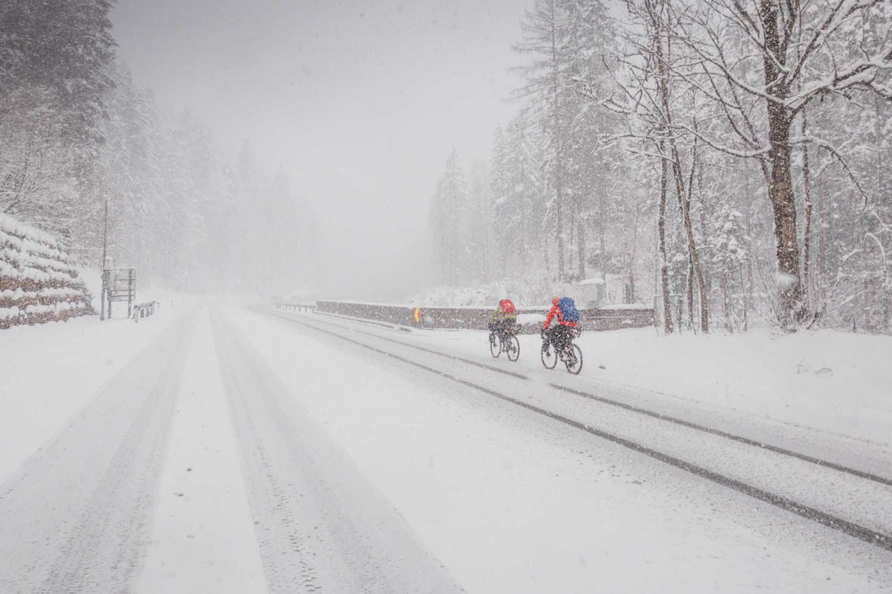 Zwei Radfahrer auf einer verschneiten Straße
